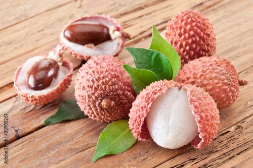 Lychee with leaves on a wooden table. photo