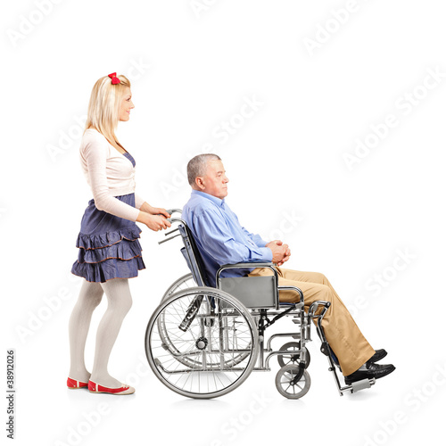 Full length portrait of a daughter pushing her dad in a wheelcha