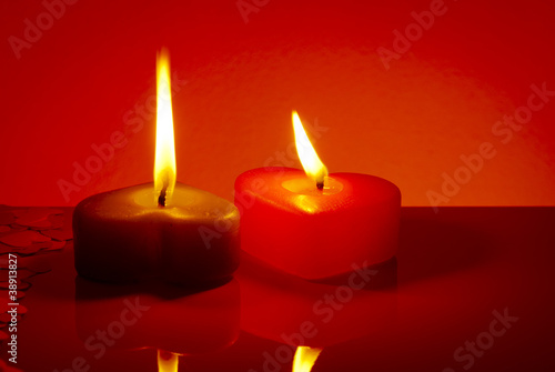 Two burning heart shaped candles