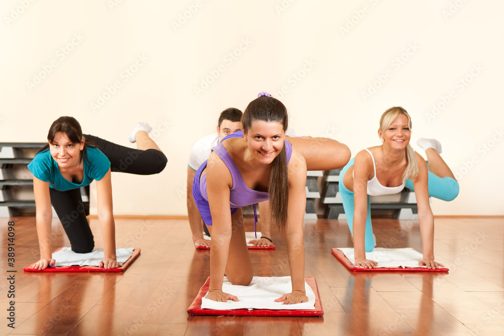 four people is doing exercises in fitness club