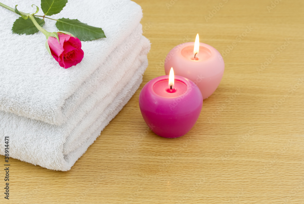 White towels with pink candles and red rose spa concept