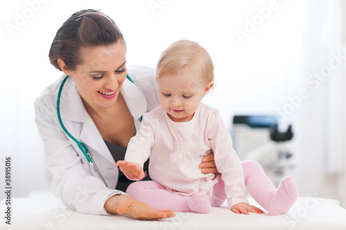 Cheerful baby high five to pediatrician doctor photo