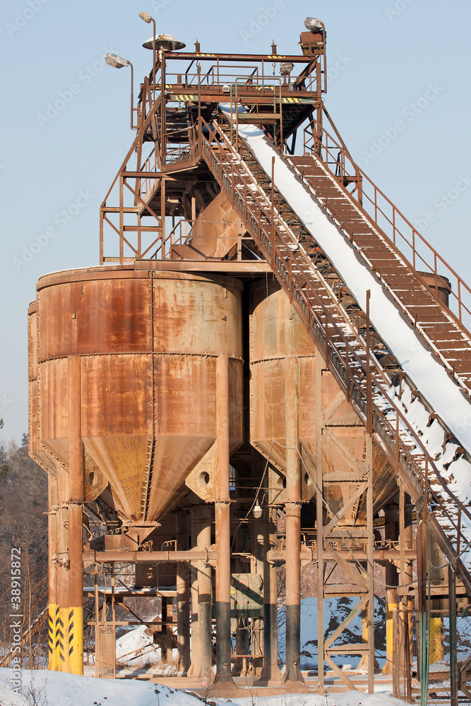 Belt conveyors and silos in a gravel pit in winter