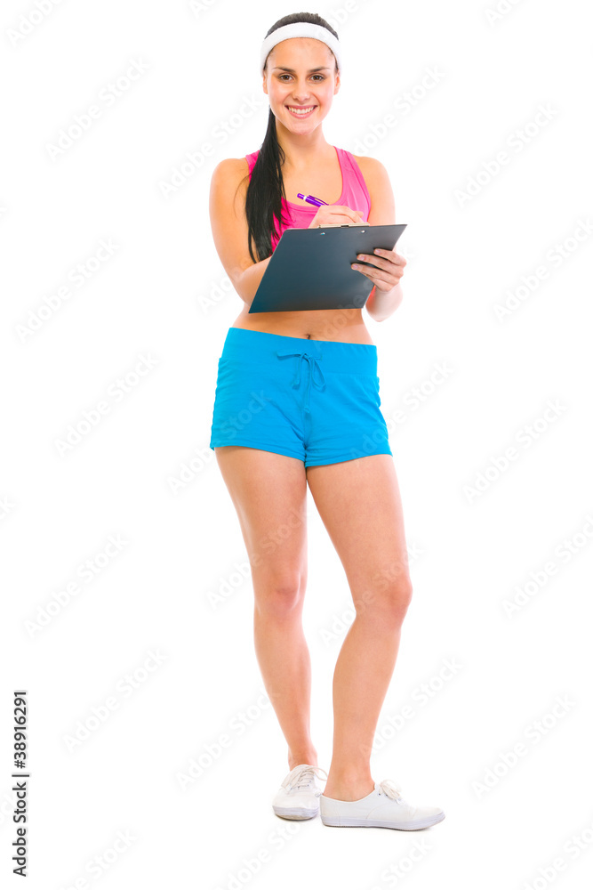 Smiling fitness girl writing on clipboard Smiling fitness girl writing on clipboard