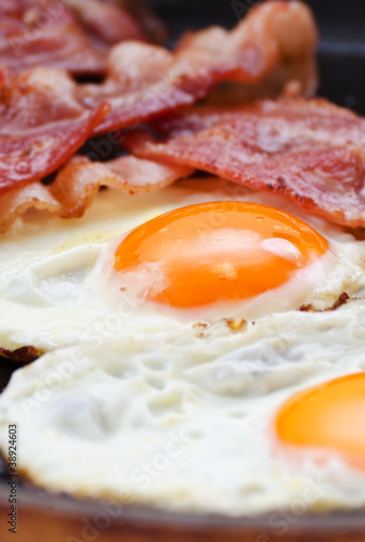 Fried eggs with bacon in a pan