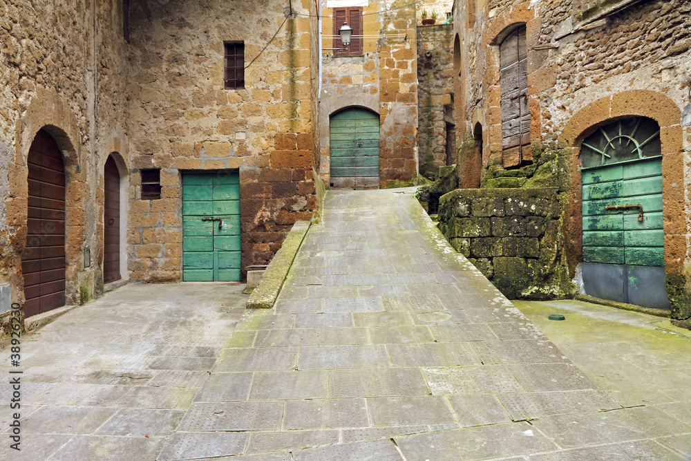 narrow inclined street in italian borgo Pitigliano, Tuscany, Eur