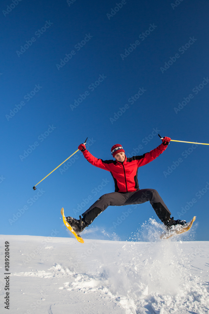 Young man having fun while snowshoeing outdoors Young man having fun while snowshoeing outdoors