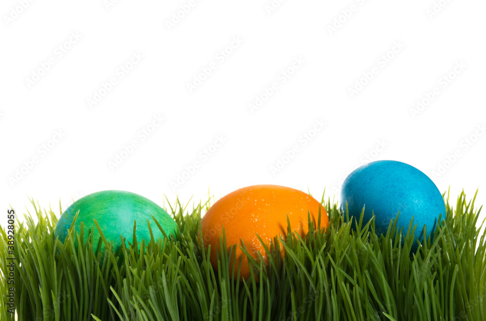 Three dyed Easter eggs in the grass