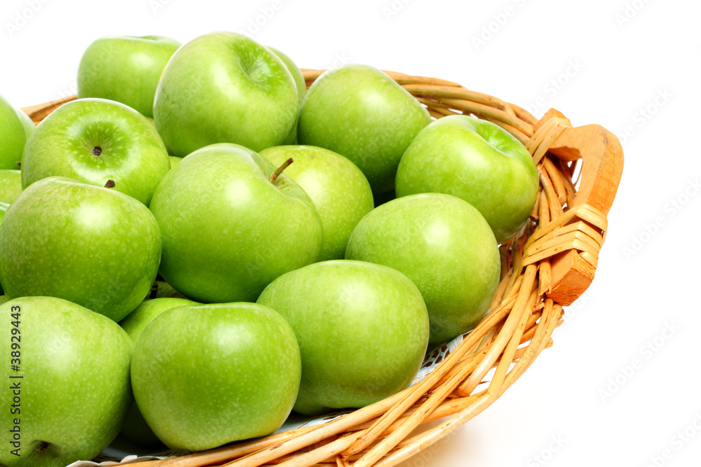 Granny Smith apples on a wicker tray, isolated on white Granny Smith apples on a wicker tray, isolated on white