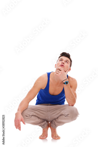 pensive man squatting down in bare feet