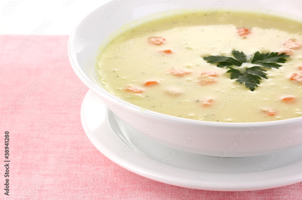 Tasty soup on pink tablecloth isolated on white