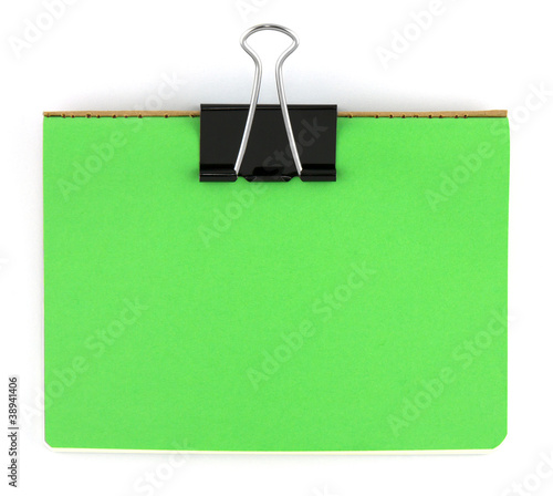 Black clip and green blank note paper