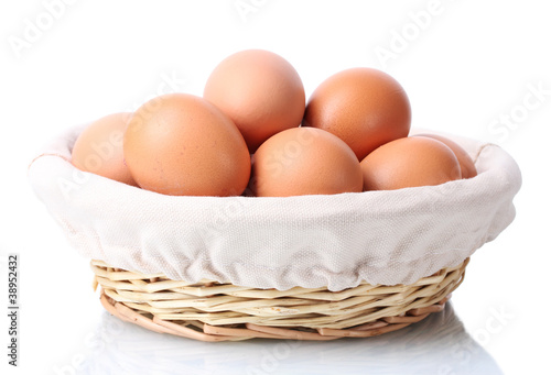 brown eggs in basket isolated on white