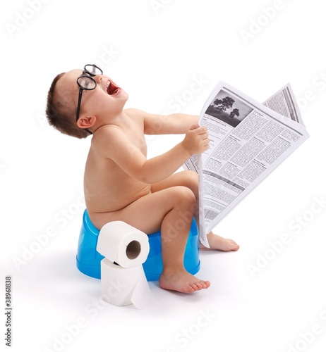 Little boy sitting on potty with newspaper photo