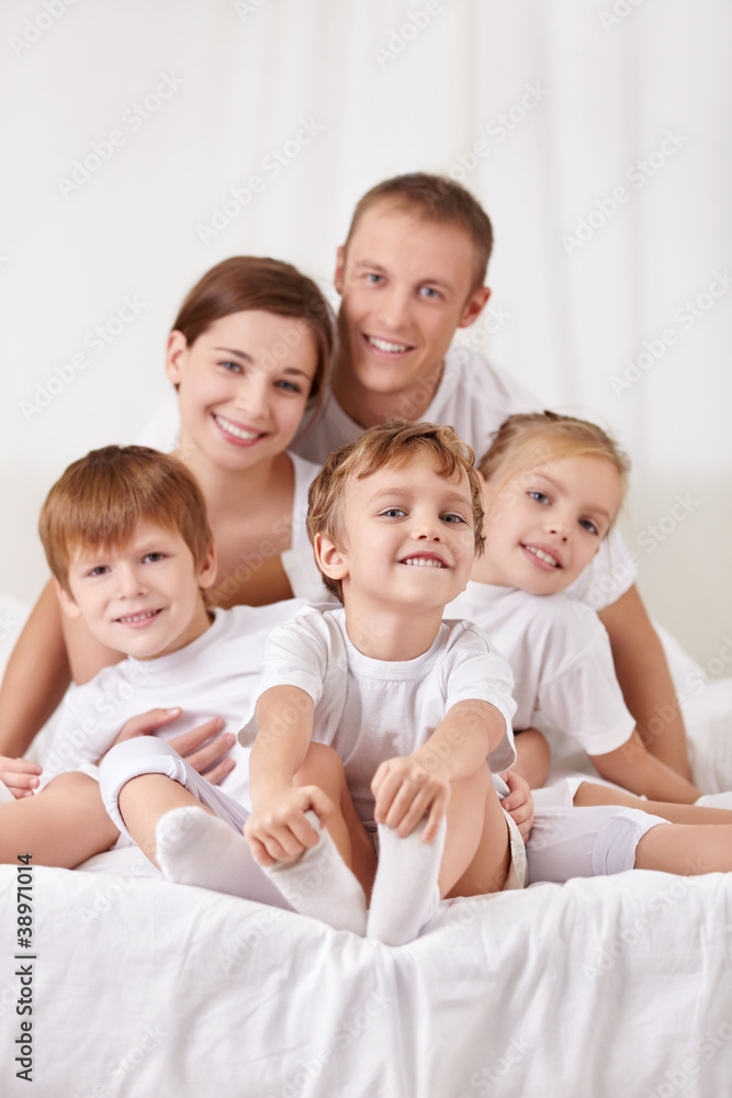 Smiling family with children in bed Smiling family with children in bed