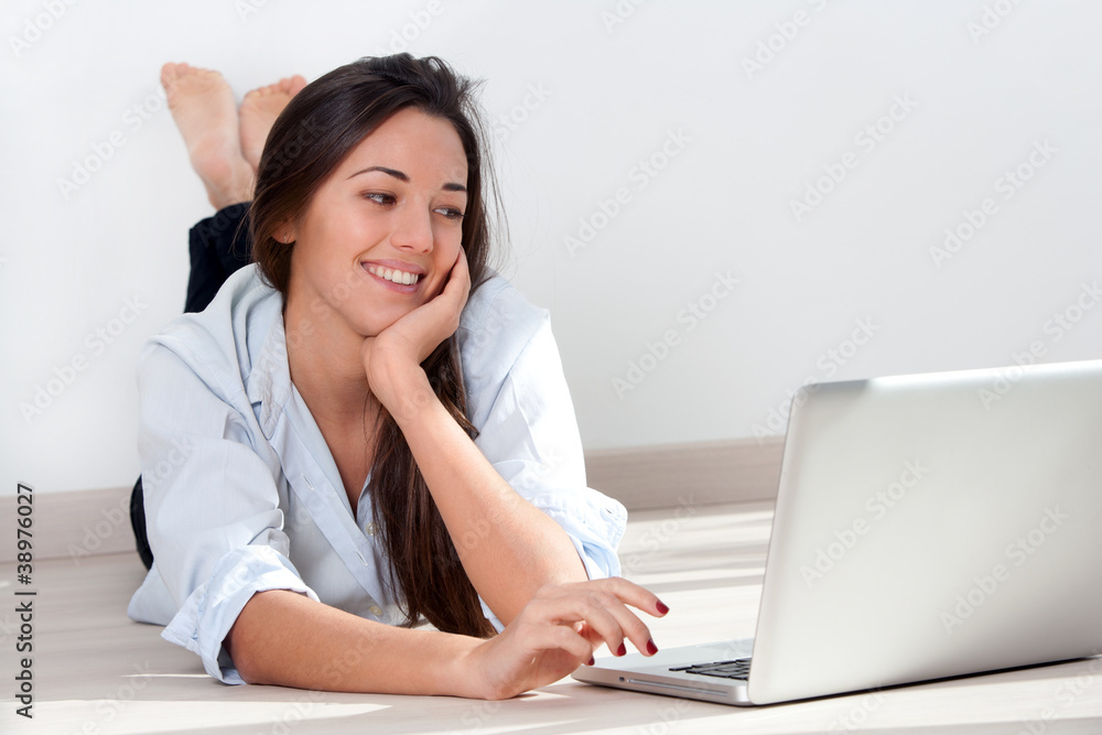 Young woman laying on floor with laptop Young woman laying on floor with laptop