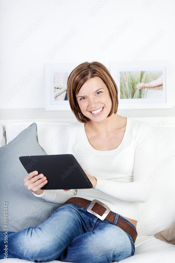 lächelnde frau mit tablet-computer auf dem sofa lächelnde frau mit tablet-computer auf dem sofa