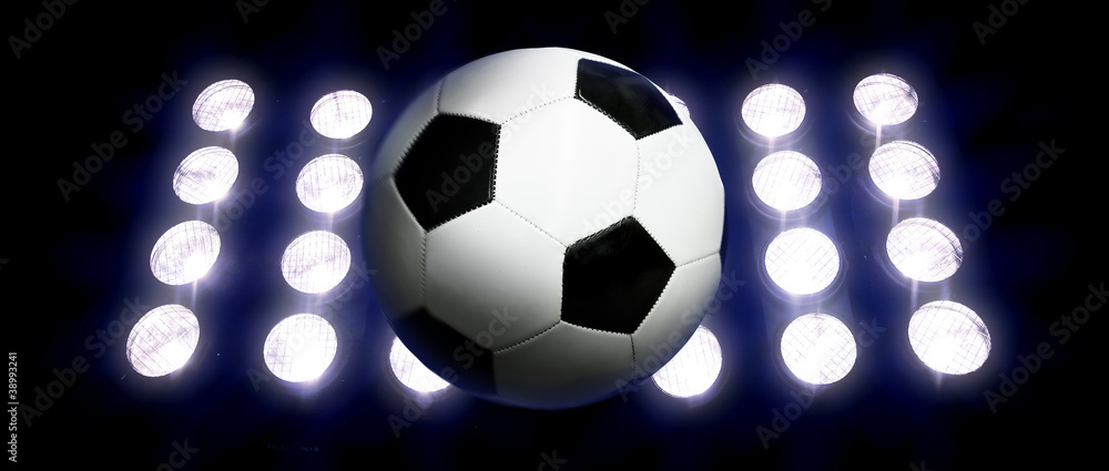 Naklejka premium Soccer ball and spotlights at night