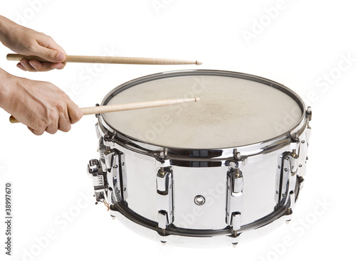 Male hand playing big metal snare drum isolated on white