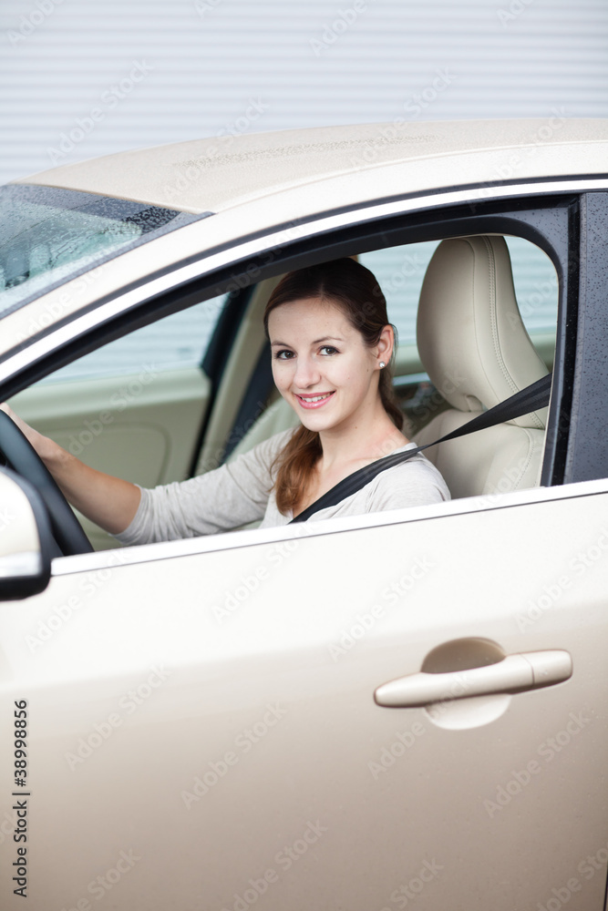 Pretty young woman driving her new car