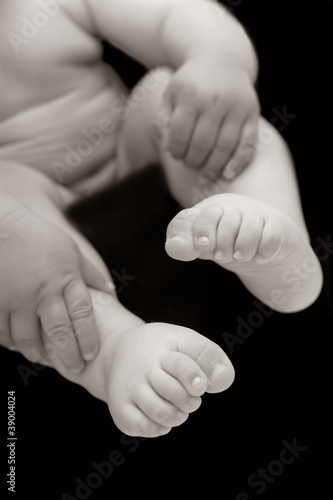 Baby mit Detailansicht von Fuessen und Haenden