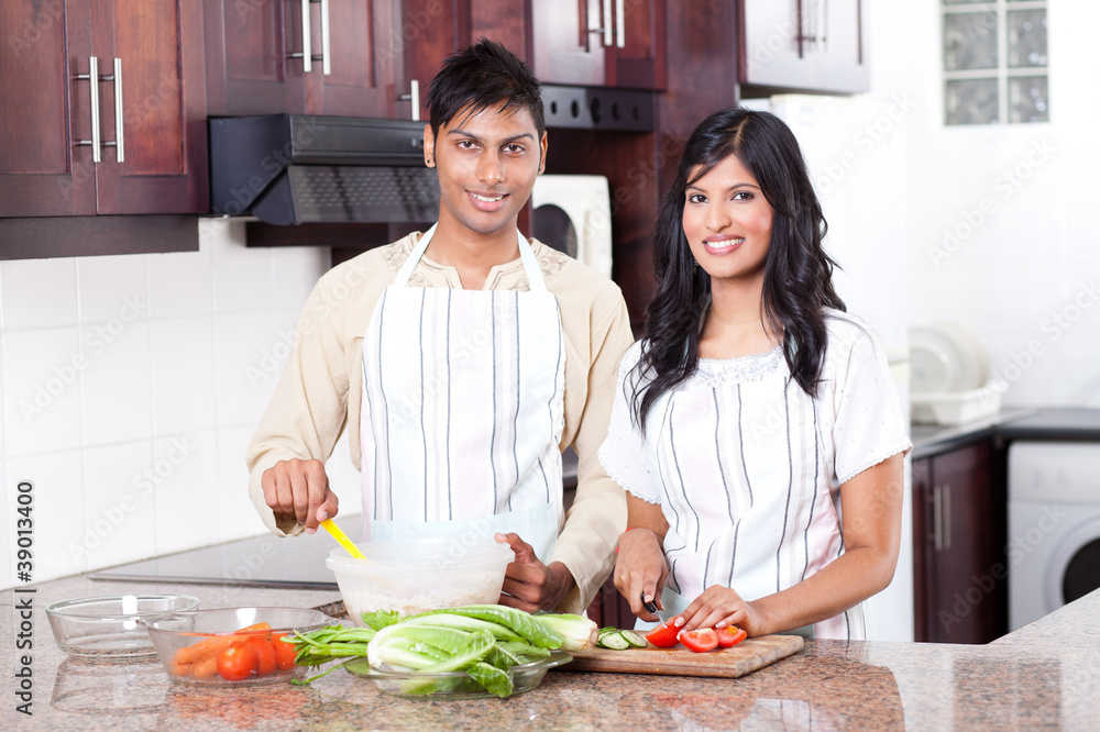 young indian couple cooking in kitchen