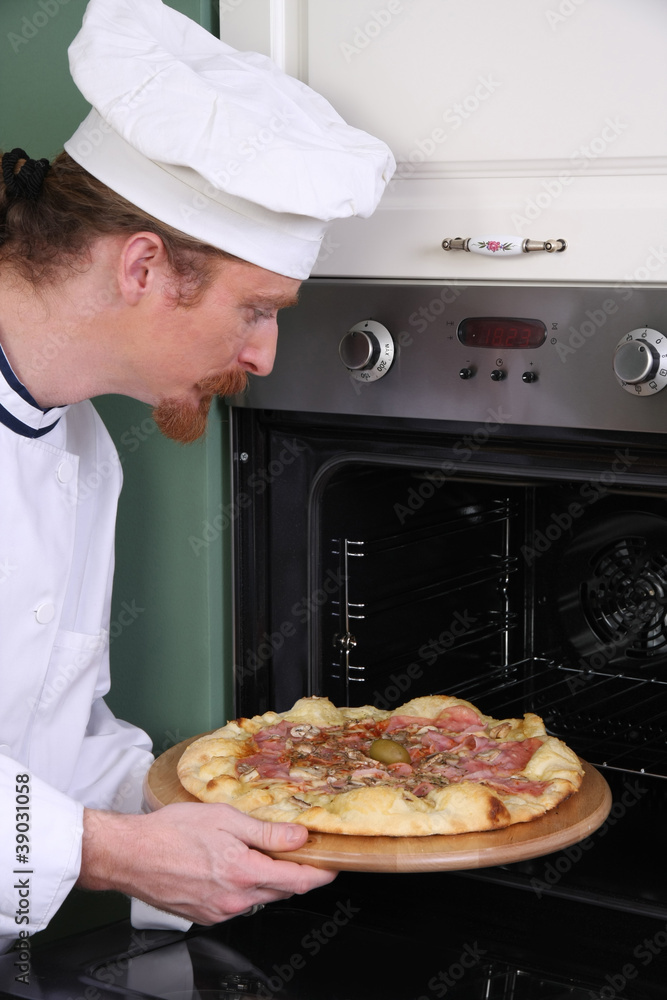 Young chef prepared italian pizza in kitchen Young chef prepared italian pizza in kitchen