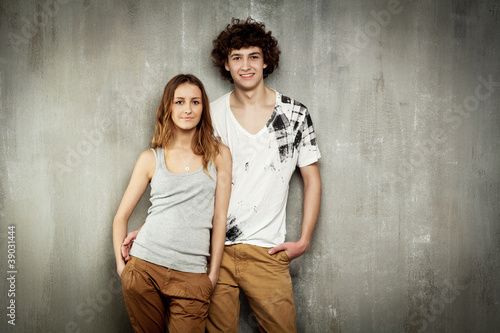 Artistic portrait of a young couple on a gray, textural backgrou photo