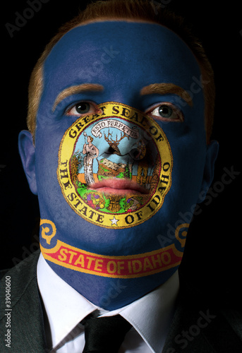 us state of idaho flag painted face of businessman or politician photo