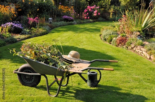 Schubkarre und Gießkanne im herbstlichen Garten