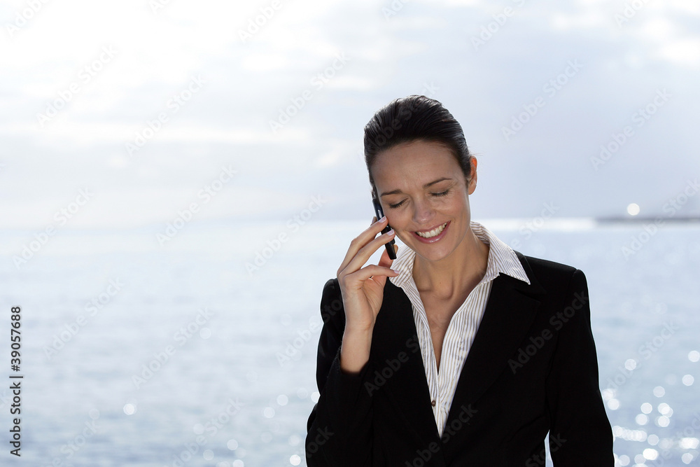 Businesswoman talking on her mobile phone on the waterfront Businesswoman talking on her mobile phone on the waterfront