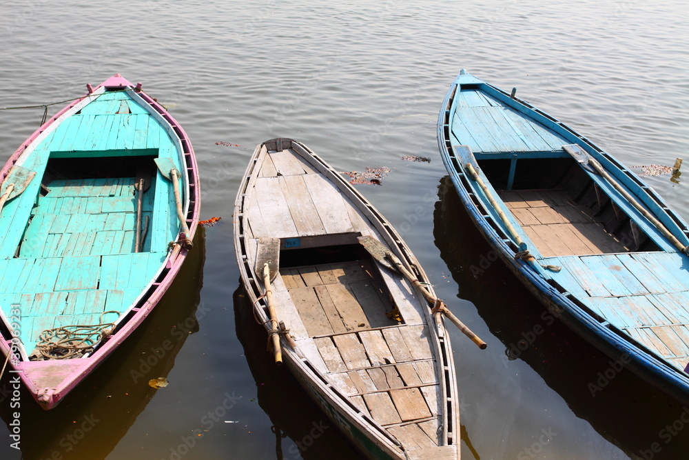 Colorful boats on brown waters of Ganges river, Varanasi, India