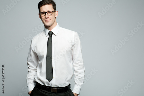 Handsome businessman in white shirt on gray background.