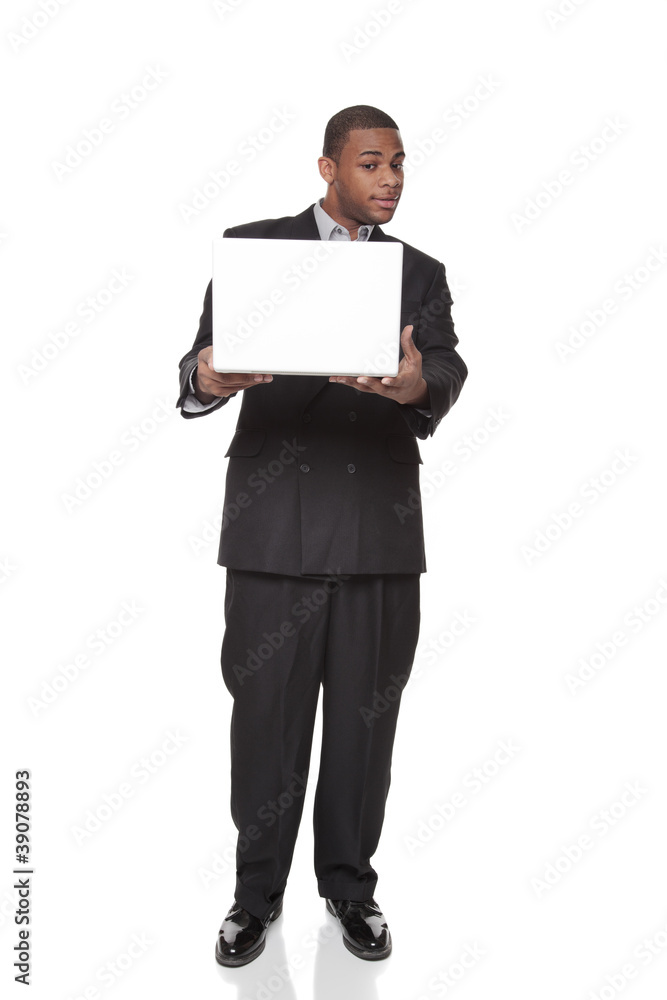African American businessman looking warily at laptop computer African American businessman looking warily at laptop computer