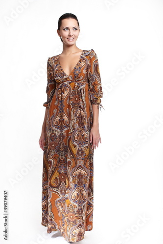 Young beautiful smiling woman in colorful brown summer dress