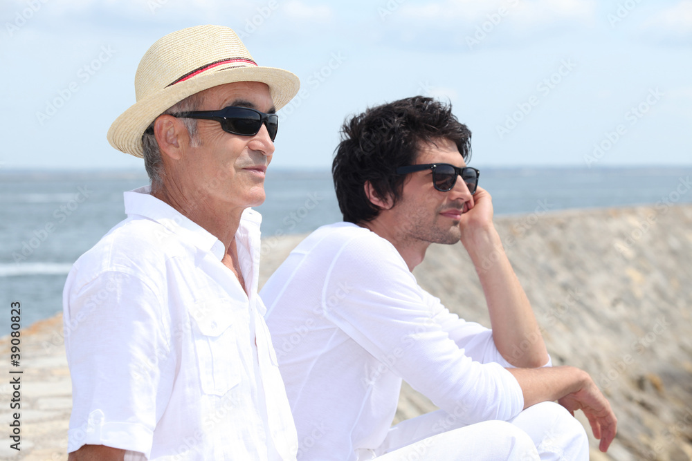 A father and his son looking at the sea.