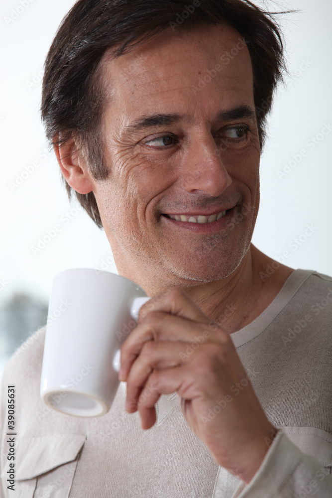 Man smiling with a cup of tea. Man smiling with a cup of tea.
