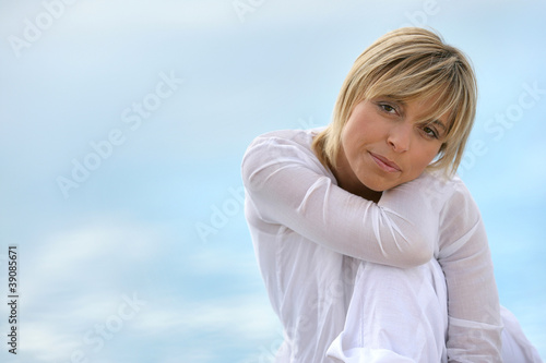 Blond woman sat touching shoulder
