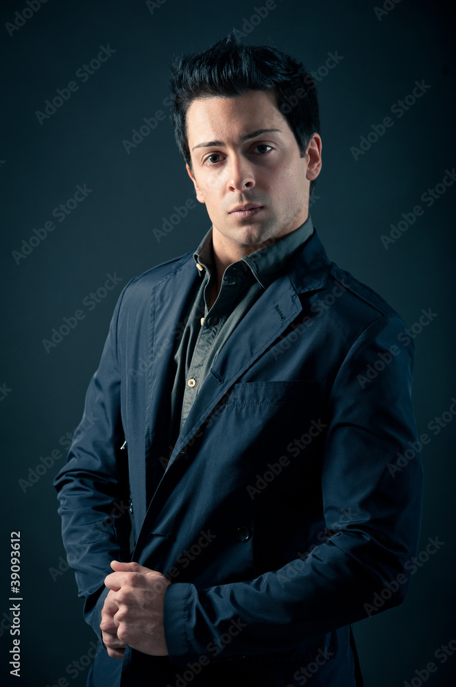 Portrait of handsome, confident man against dark background. Portrait of handsome, confident man against dark background.
