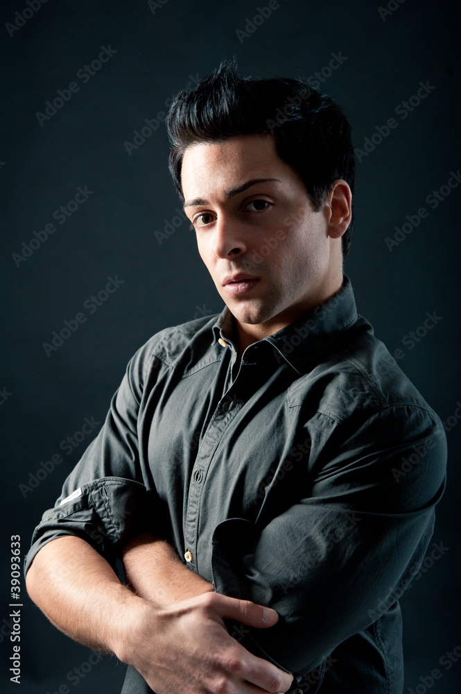 Portrait of handsome, confident man against dark background. Portrait of handsome, confident man against dark background.