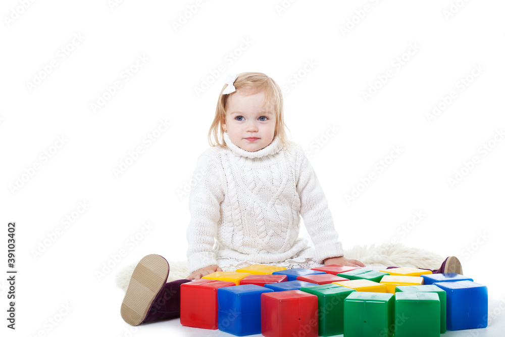 Baby girl plays with toy blocks over white background Baby girl plays with toy blocks over white background