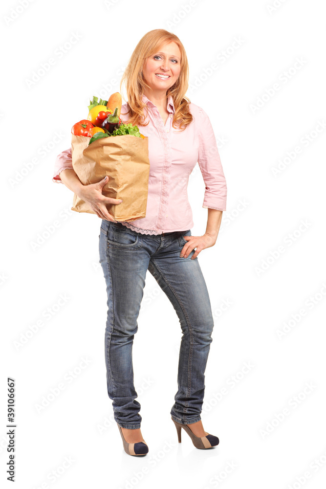 Smiling woman holding a paper bag full of groceries