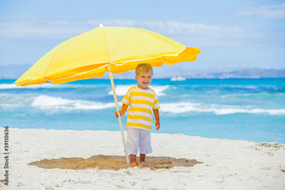 Boy with big umbrella on tropical beach Boy with big umbrella on tropical beach