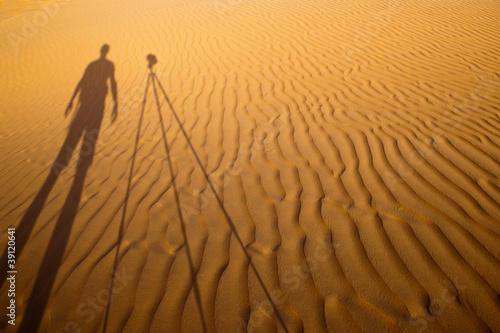 Photos Shadow of a photographer standing next to his tripod