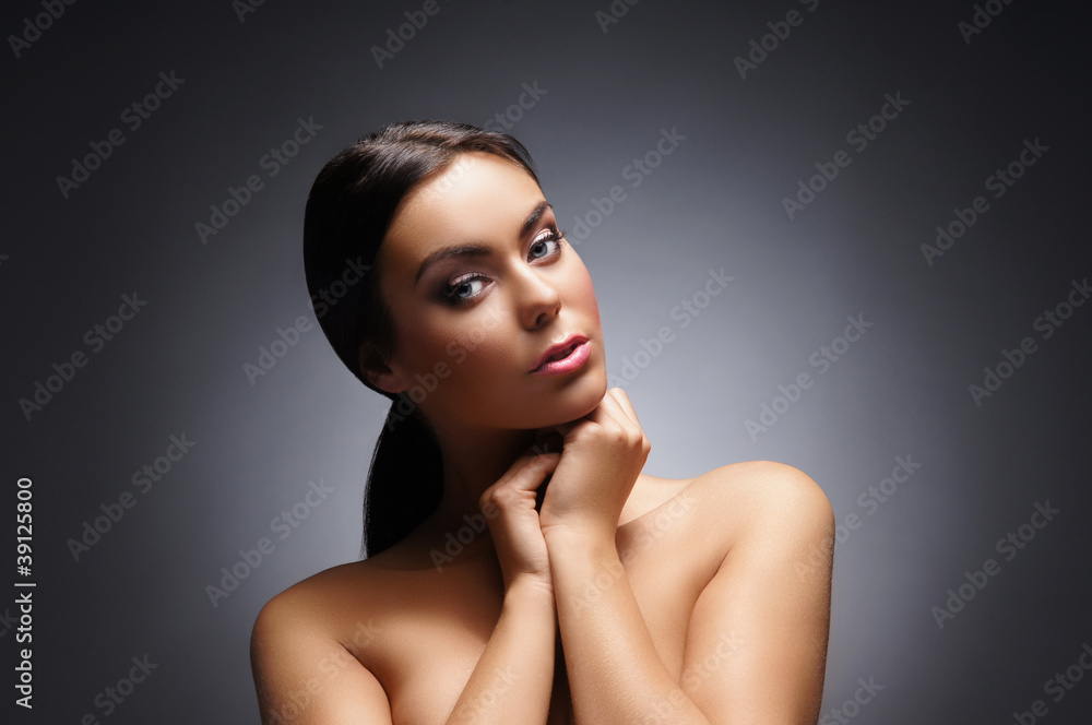Fototapeta premium Portrait of a young and beautiful woman over grey