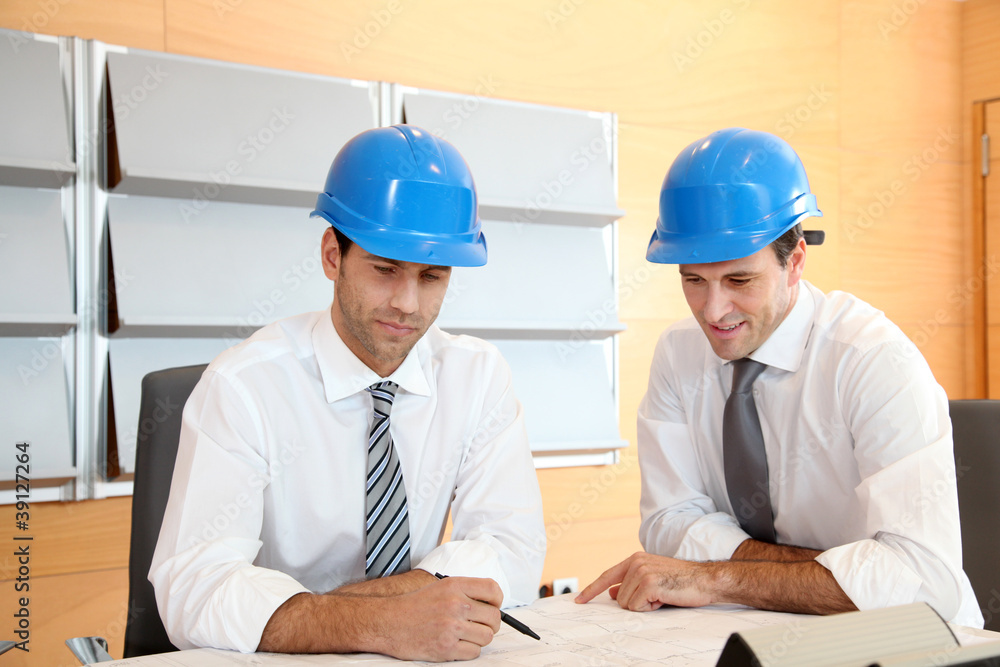 Team of architects working on construction plan Team of architects working on construction plan