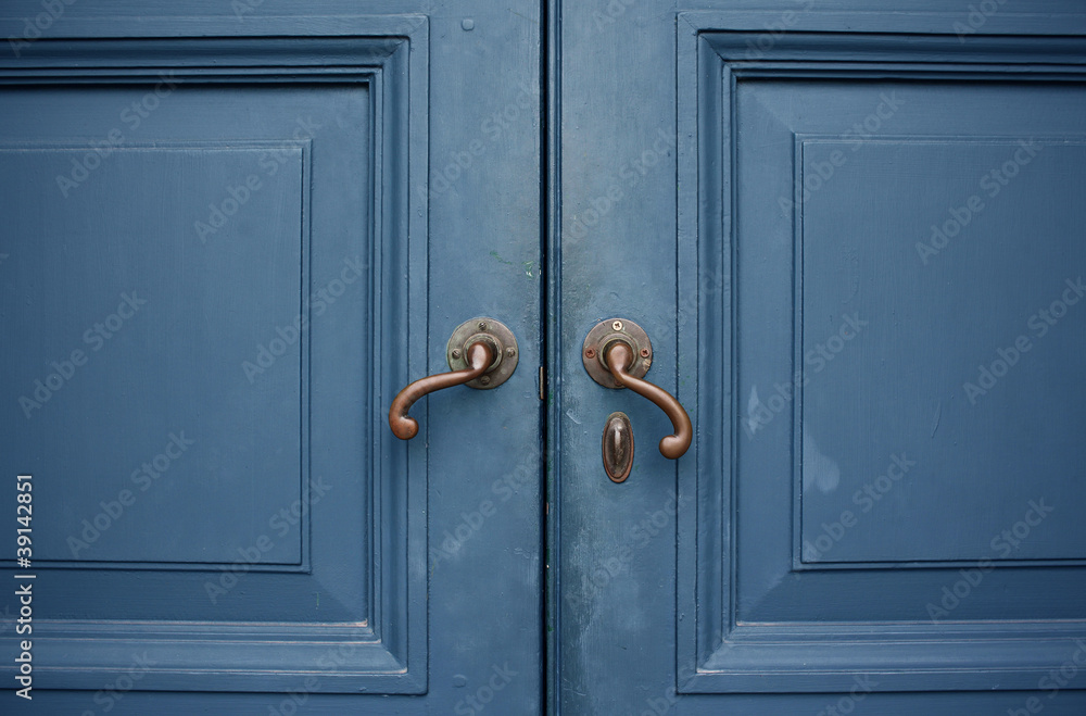 Door handles with an old double wood door blue color Door handles with an old double wood door blue color