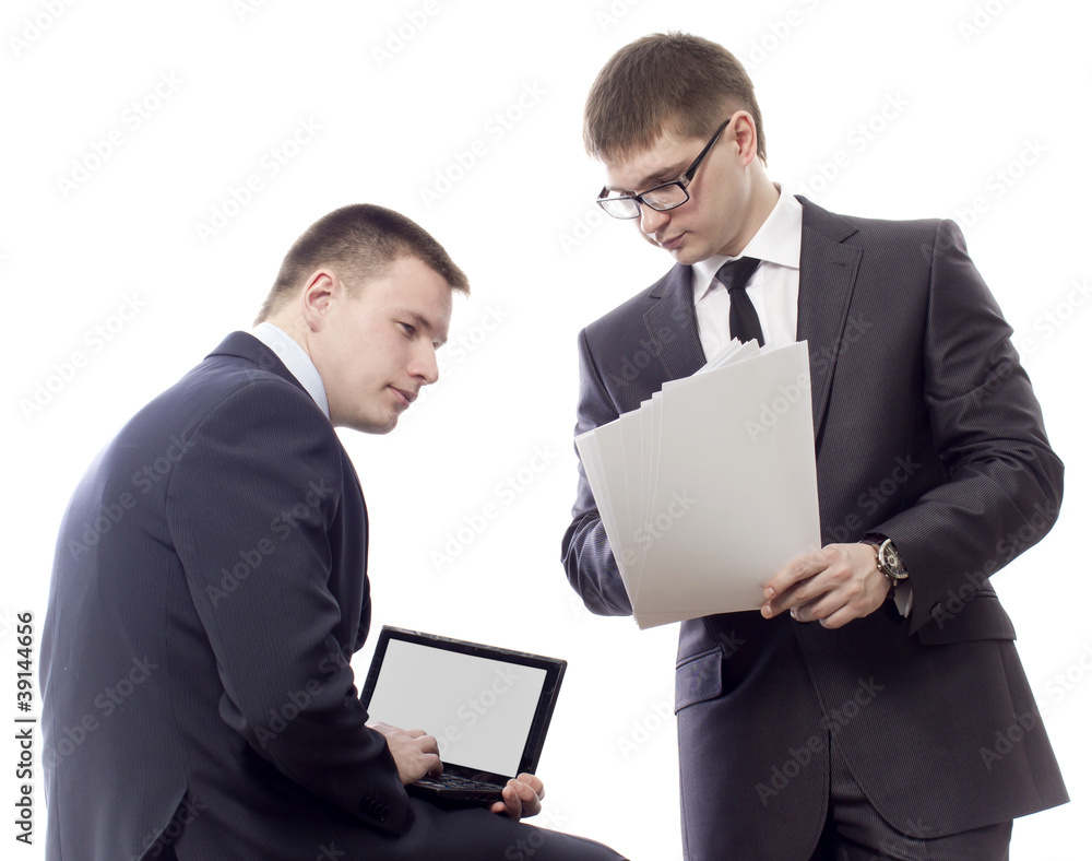 Two men one another with documents talk to the computer Two men one another with documents talk to the computer