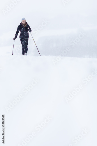 Cross-country skiing: young woman cross-country skiing on a snow