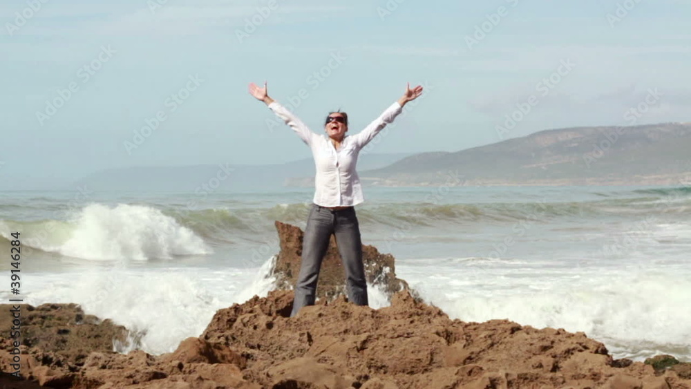 Successful businesswoman raising hands to the sky by the sea Successful businesswoman raising hands to the sky by the sea